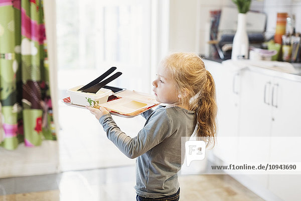 Side view of girl carrying food tray in preschool