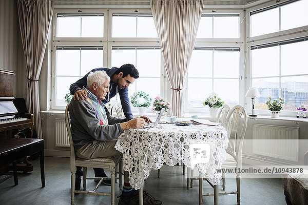 Senior Mann mit Laptop und Hausmeister im Pflegeheim