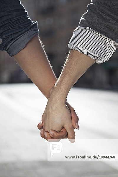 Nahaufnahme von Mann und Frau beim Händchenhalten