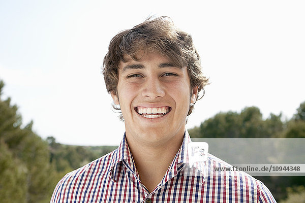Close up portrait of handsome young man smiling outdoors