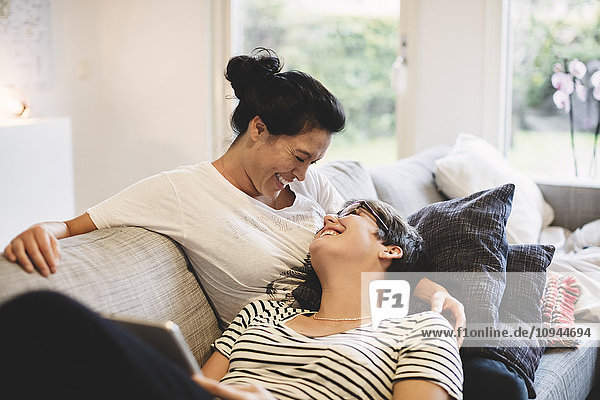 Smiling lesbian couple embracing in living room at home