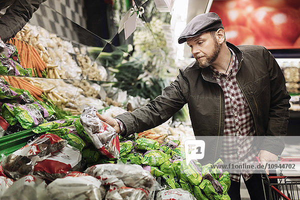 Mann kauft frisches Gemüse im Supermarkt