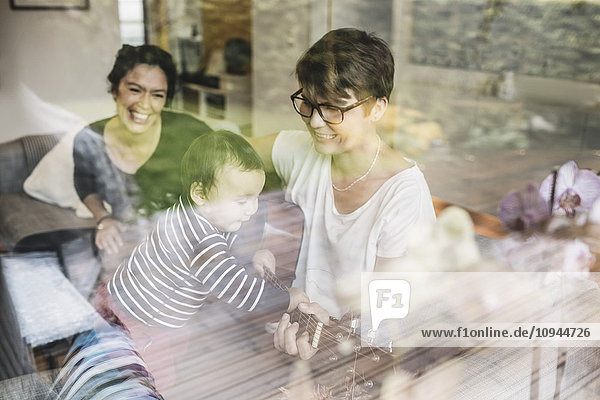 Lächelnde Familie genießt Musik durch das Glasfenster gesehen