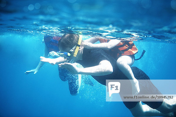 Thailand  adult diver wtih child on back