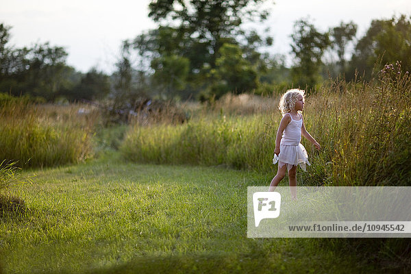 Blonde girl standing on meadow