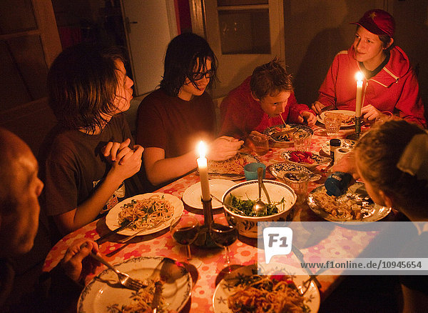 Family with teenage boys eating candlelit dinner