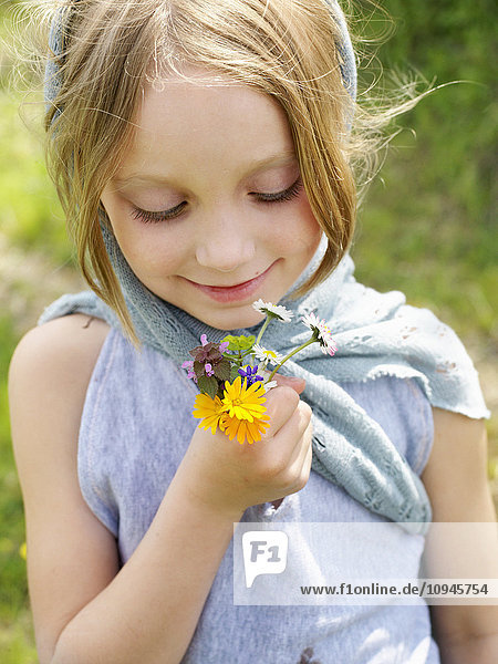 Mädchen hält einen Strauß Wildblumen