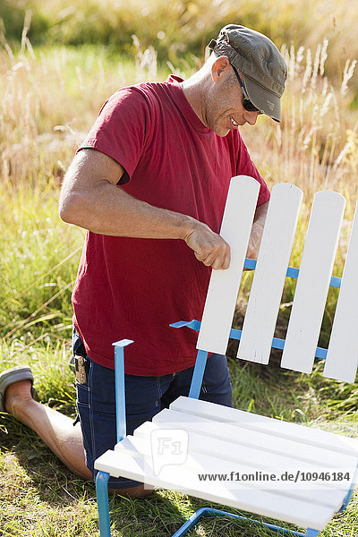 Man repairing outdoor chair