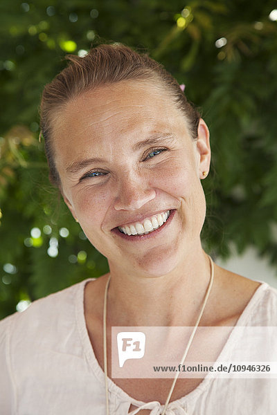 Porträt einer mittleren erwachsenen Frau mit zahnigem Lächeln