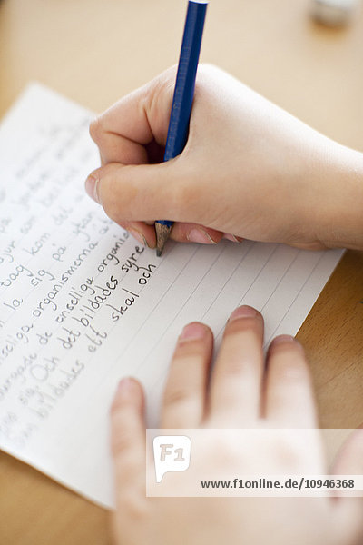 Kind schreibt in Notizbuch  Nahaufnahme der Hand