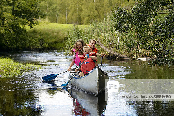 Family canoeing on river