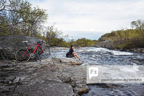 Cyclist sitting at river