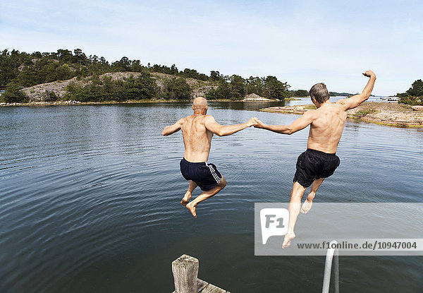 Zwei Männer springen ins Meer
