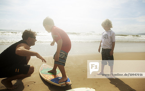 Mann bringt Jungen das Surfen bei