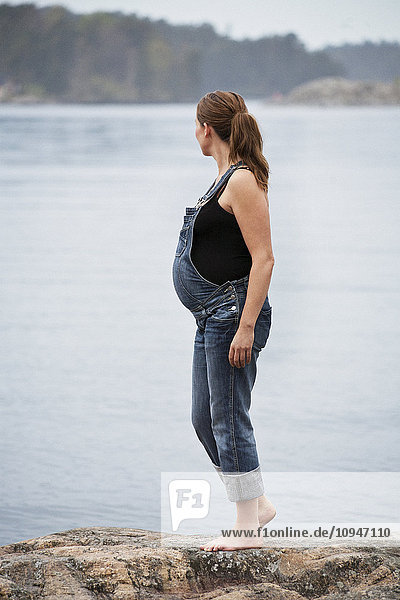 Pregnant woman standing on rock