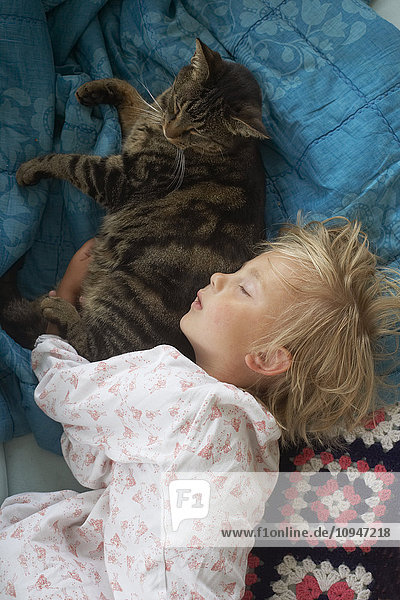 Mädchen schläft mit Katze