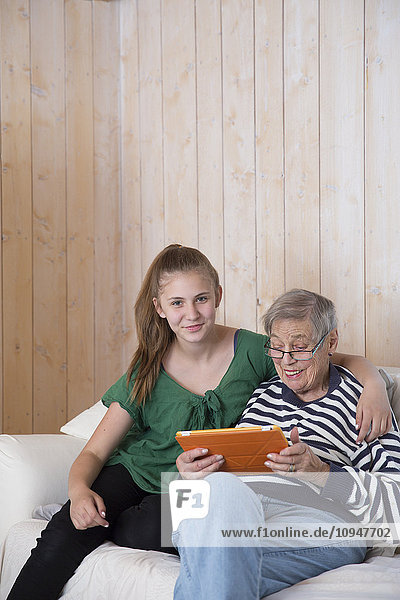 Großmutter und Enkelin benutzen Tablet