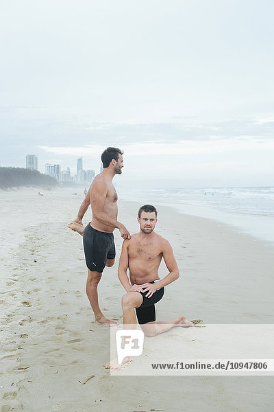 Men stretching on beach