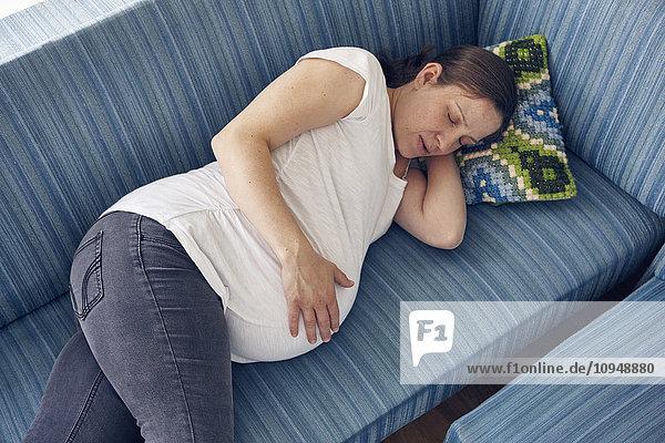 Schwangere Frau schlafend auf Sofa