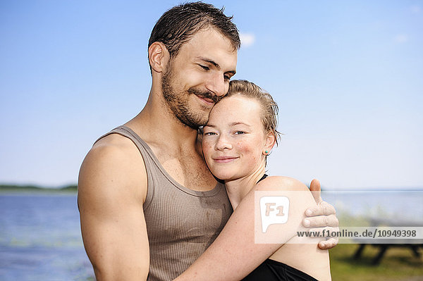 Smiling couple embracing on beach