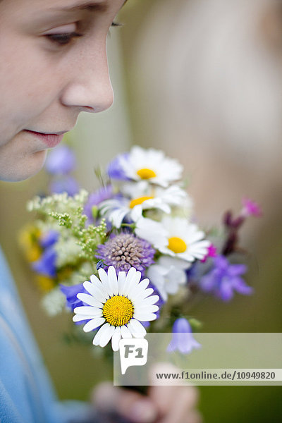 Mädchen hält Blumenstrauß aus Wildblumen