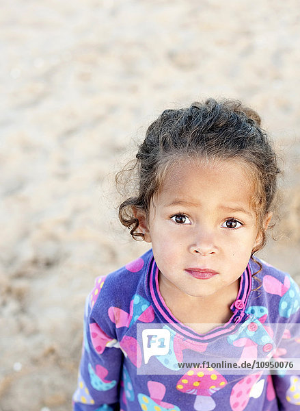 Porträt eines auf Sand stehenden Mädchens