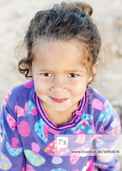 Porträt eines lächelnden Mädchens auf Sand