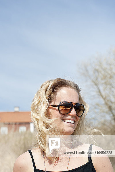 Lächelnde junge Frau mit Sonnenbrille