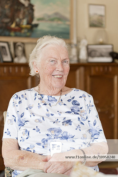 Portrait of senior woman sitting in living room
