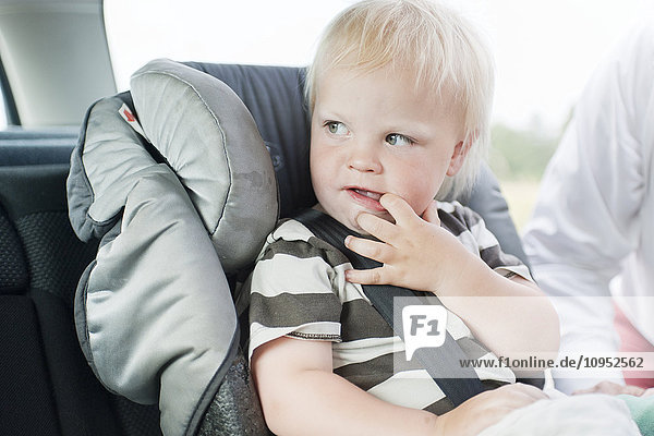 Baby im Sicherheitssitz im Auto sitzend