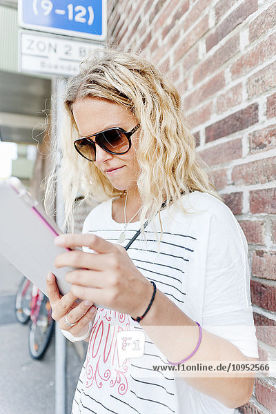 Blonde Frau mit digitalem Tablet