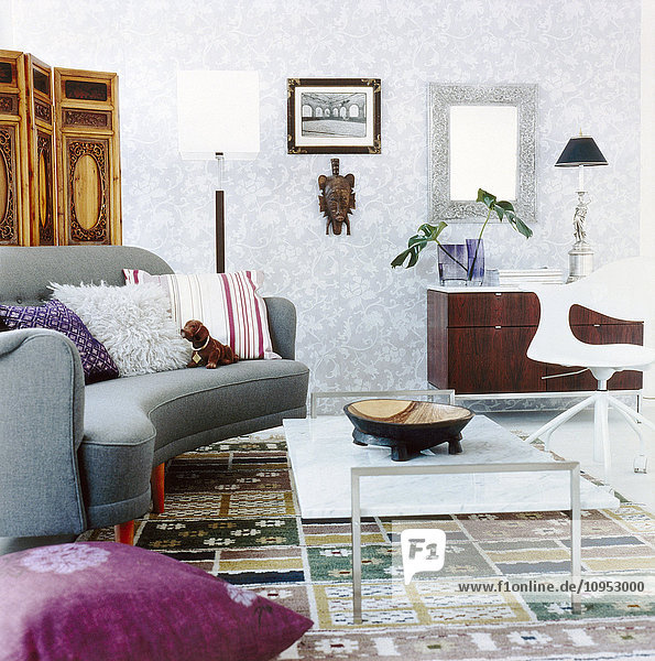 Das Wohnzimmer ist mit Möbeln und einem Spiegel an der Wand ausgestattet.