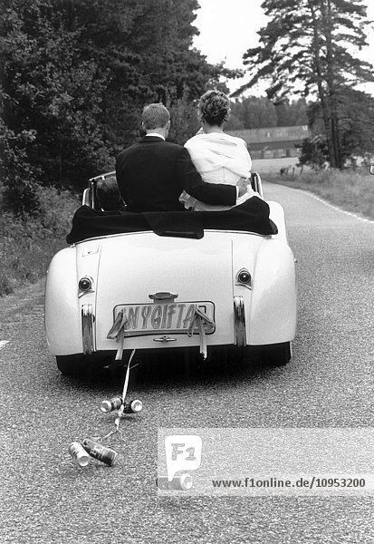 Ein Brautpaar in einem Auto.