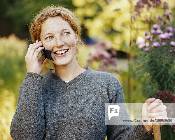 Portrait of red-haired woman talking in the phone.