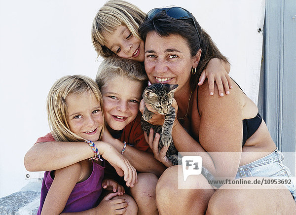 Porträt einer Mutter mit Töchtern und Kätzchen