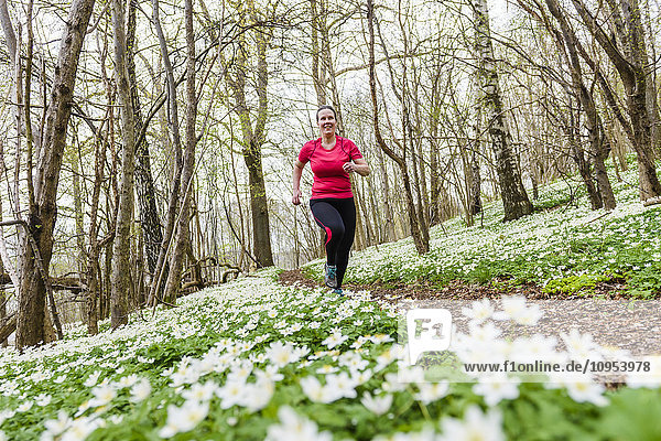 Frau läuft im Frühlingswald