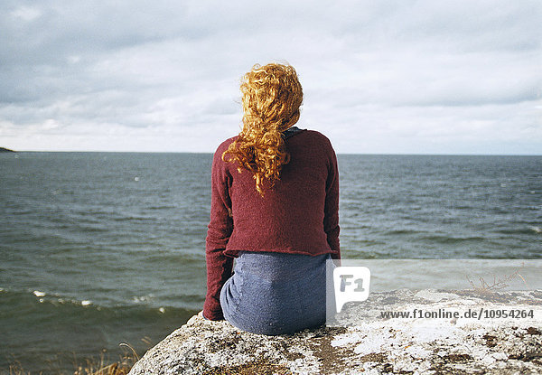 Redhead woman looking at sea  rear view
