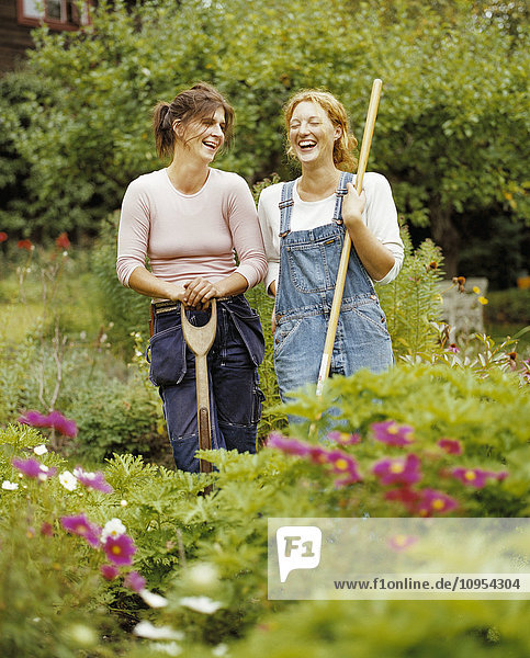 Women standing in the garden laughing.