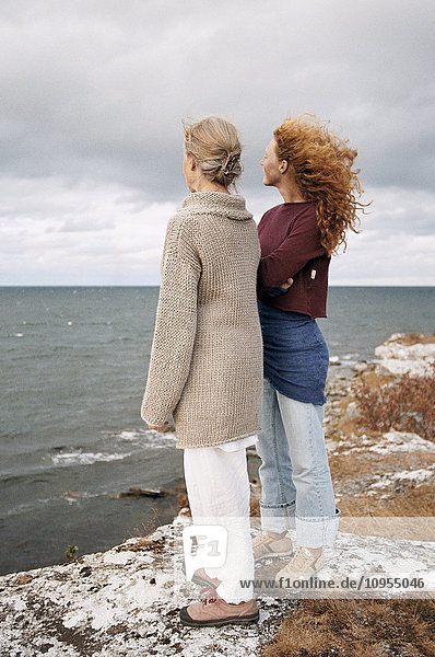 Mother and adult daughter looking at sea