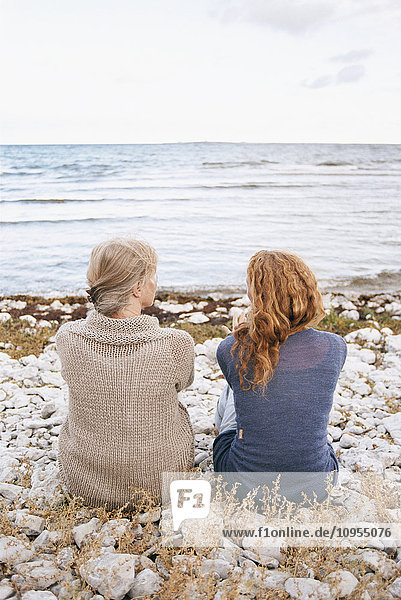 Mother and adult daughter looking at sea
