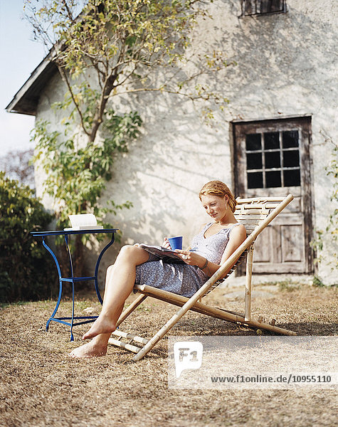 Frau liest Buch auf Sonnenstuhl