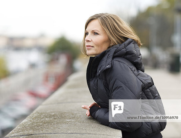 Porträt einer Frau  die an einer Steinmauer lehnt  Schweden.
