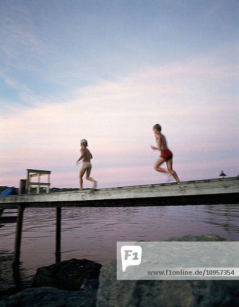 Two children going for a swim in the evening  Sweden.