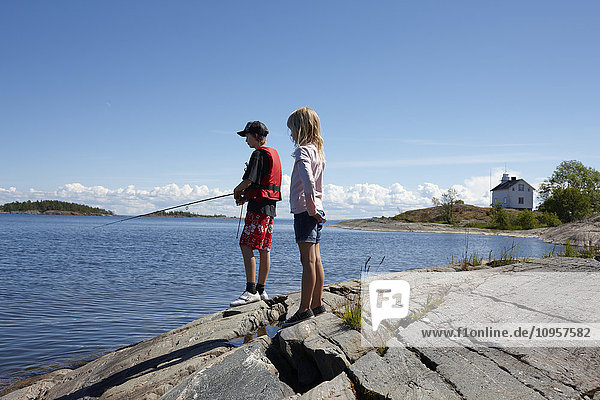 Boy and girl fishing  Sweden.