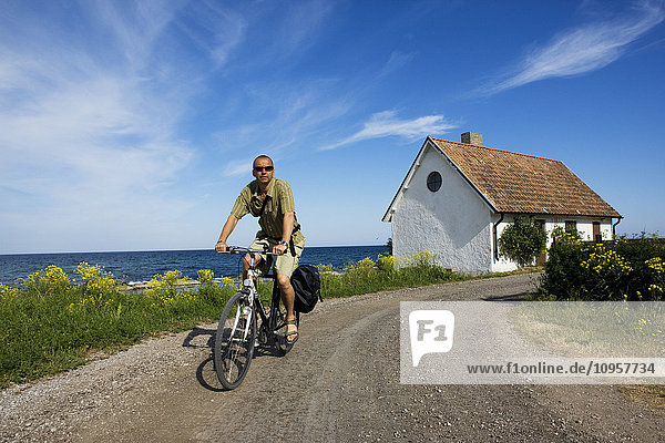 Mann beim Radfahren am Meer  Schweden.
