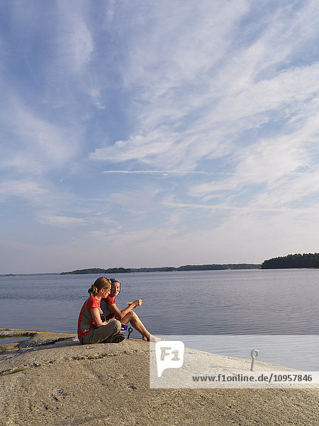 Two women having breakfast by the sea  Sweden.