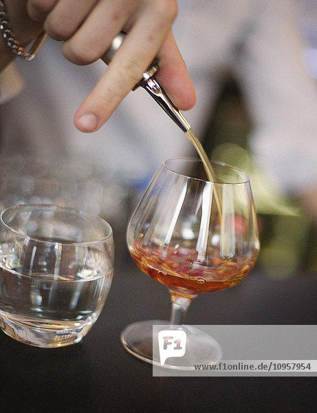 Bartender pouring cognac into a glass  Sweden.