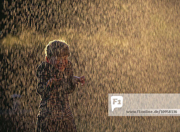 Boy playing in a water cascade  Sweden.