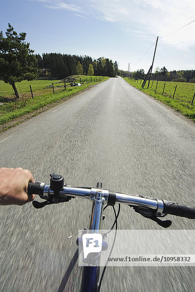 One person biking on a small road in the countryside  Sweden.