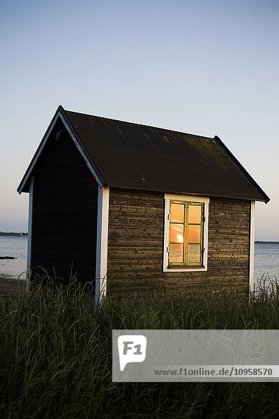 A small cottage by the sea at sunset  Sweden.